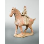 A painted pottery figure of a horse and rider, possibly Tang Dynasty, the seated rider astride a