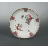 A Tournai dish, circa 1780, painted to the centre with scattered floral bouquets within puce trellis