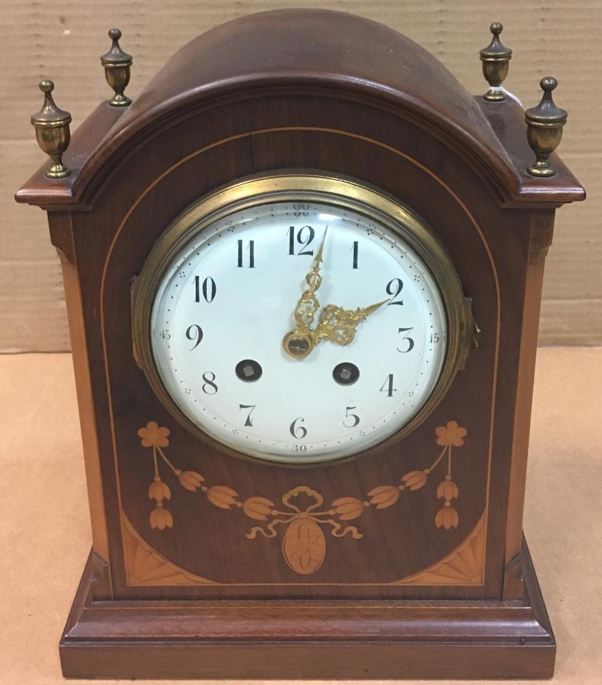 An Edwardian mahogany and satinwood inlaid mantel clock, the breakarch case with four brass urn