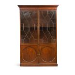 A George III mahogany bookcase, with astragal glazed doors above two circular panel cupboard