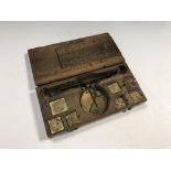 A walnut cased coin balance scale, German, 18th century, stamped with various coin denominations,