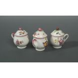 Three Mennecy custard cups and covers, circa 1760, each decorated with scattered floral sprays,