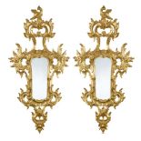 A pair of Florentine carved giltwood wall mirrors, 20th century, with open leaf and scroll border