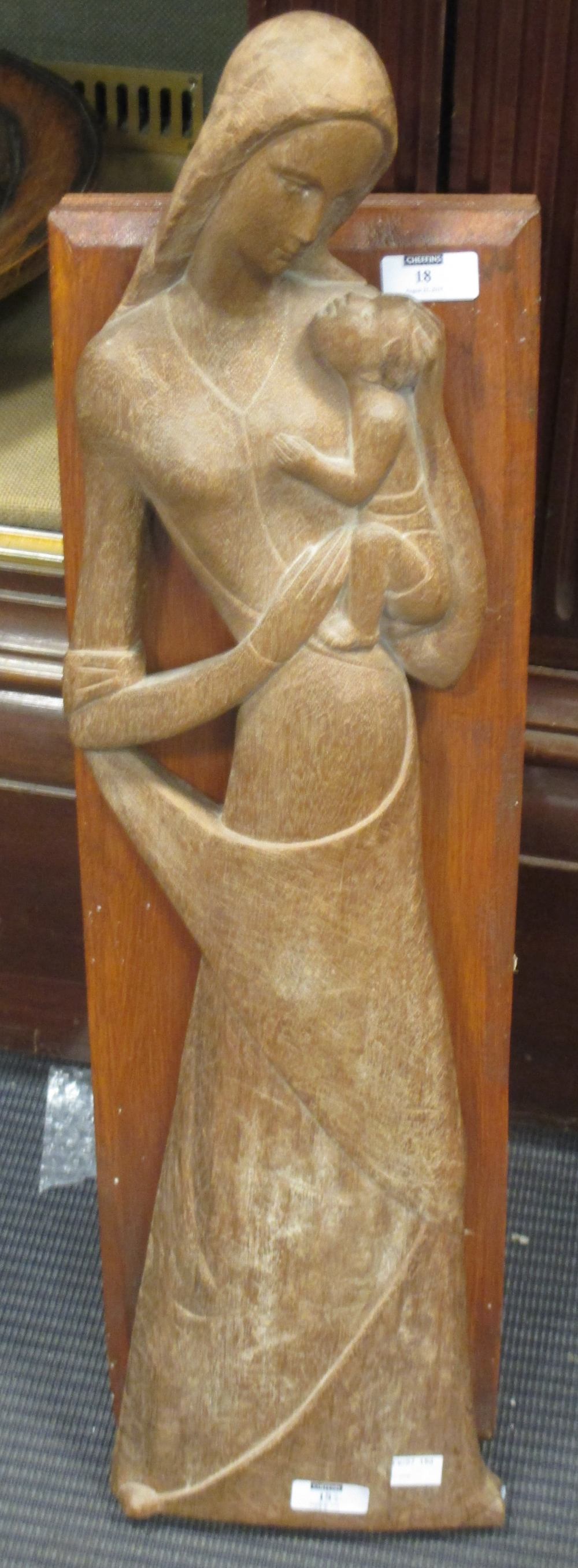 A carved oak figure of Madonna and child in flattened perspective, signed 'Demetz Eugen' and dated