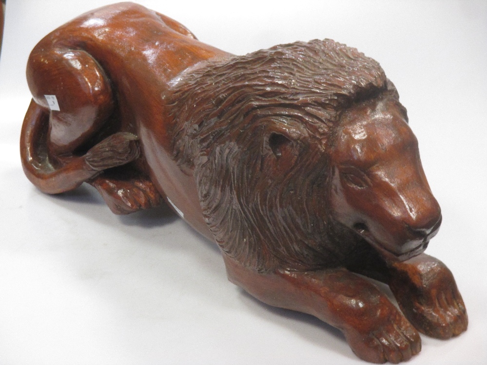 A carved and stained pine model of a recumbent lion, 59 cm wide - Image 2 of 6