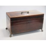 An early 19th century mahogany tea caddy on ball and claw feet