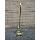 A brass standing lamp in the form of a Corinthian column, on a stepped base with four paw feet (