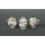 Three Mennecy custard cups and covers, circa 1760, each decorated with scattered floral sprays,
