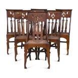 A set of six Arts & Crafts oak dining chairs, the pierced back rails sweeping down to rush seats,