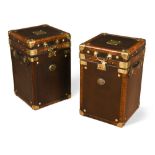 A pair of modern brass-bound leather trunks or bedsides, each with hinged top and leather strap