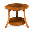 An Art Deco walnut occasional table, the shaped top on three outswept supports united by an