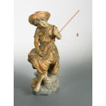 A Goldscheider terracotta model of a young girl fishing, she sits perched upon a rock holding her