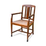 An early 20th century walnut elbow chair, possibly Austrian, the pierced back with exposed dowel