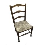 An Arts & Crafts rush seated child's chair, with shaped back rails raised on turned legs 71cm (28in)