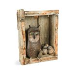 In the manner of Guy Taplin, a carved and painted wood model of an Owl feeding her chicks, set in an