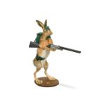A novelty taxidermy hare mount, modelled standing on hind legs, holding a shotgun in Alpine attire
