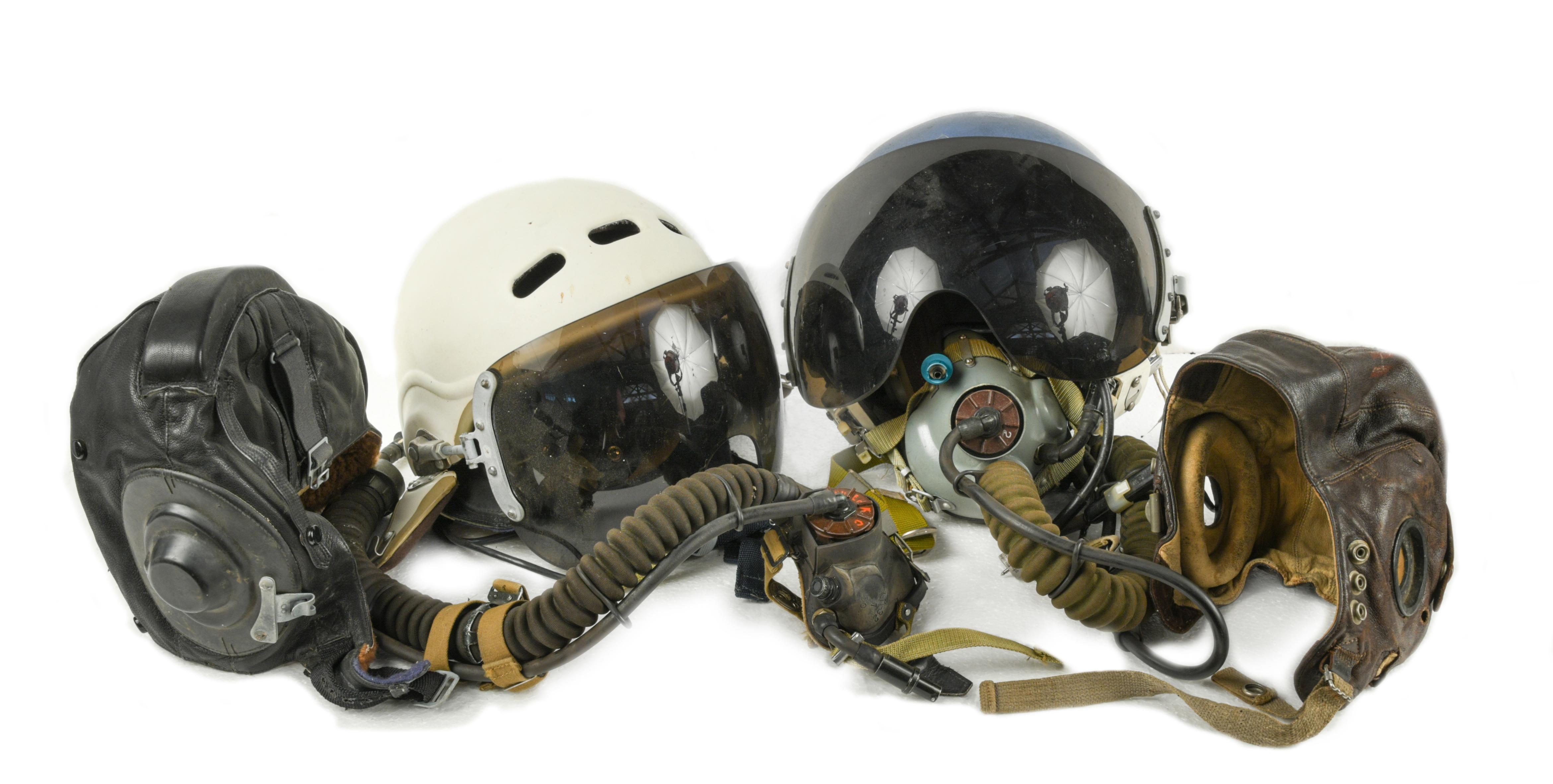 Two aviation helmets, each with tinted visors and oxygen masks, together with two other leather