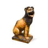 A glazed terracotta figure of a seated lion 95cm (37in)