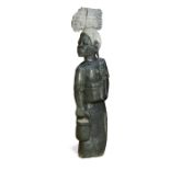 A large Zimbabwean carved green stone figure of a lady, modelled carrying firewood on her head and a