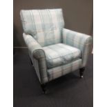 A modern blue upholstered armchair on turned legs