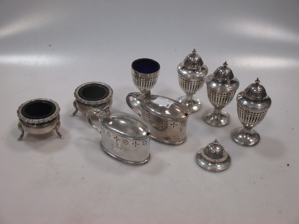 Four silver pierced pepper casters, together with a pair of open salts and a pair of mustards all