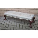 An upholstered long stool on carved legs and claw feet 117cm long