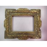 An Italian 17th Century polychrome and gilt cassetta frame with carves centres, sight size 19 x