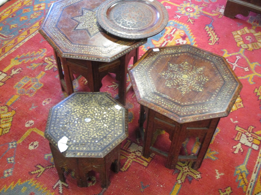 Three early 20th century Indian brass inlaid octagonal occasional tables on folding stands,