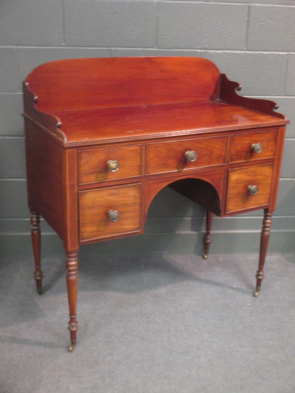 A Regency mahogany Gentleman's dressing stand with galleried back, drawers and on turned legs and