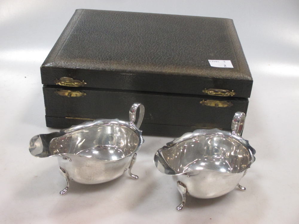 A matching pair of silver sauce boats in a presentation case, 3.3ozt gross (2)