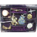 A red leather jewellery case containing a collection of gold jewellery and a gold watch together