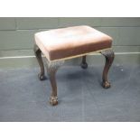 A George III style mahogany stool, with upholstered seat and ob carved cabriole legs, claw and
