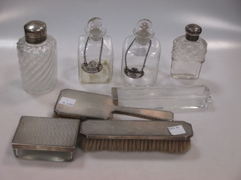 Two dressing table jars with silver tops, together with a silver backed hair and clothes brush,