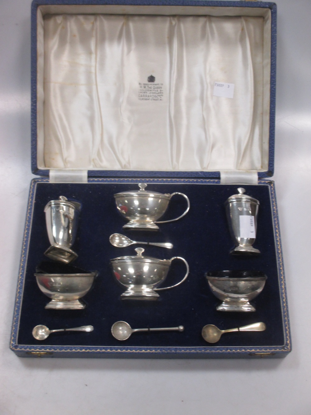 A cased six piece silver condiment set by Garrard & Co with non matching spoons 8.8ozt