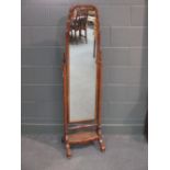 A 1930's walnut framed cheval dressing mirror with canework shelf