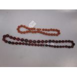 A short row of butterscotch amber-coloured beads and another necklace of dark transparent amber-type