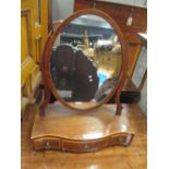 An early 19th century mahogany dressing table mirror, on a serpentine base with three drawers