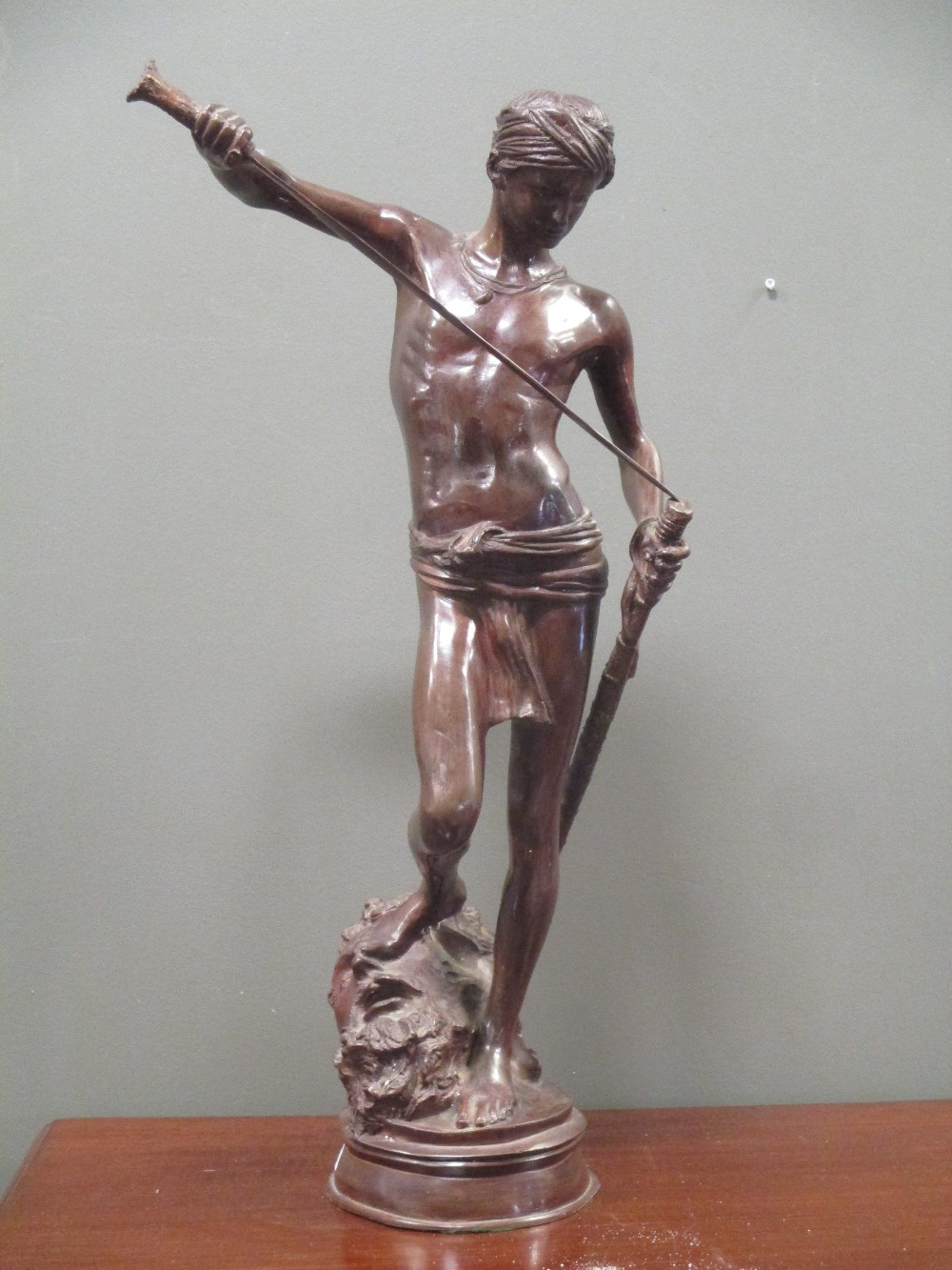 After Antonin Merice a bronze, David standing with his foot on the severed head of Goliath, 68cm