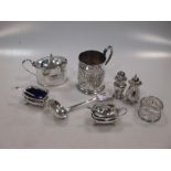 A collection of silverware including a condiment set, a mustard, a christening mug, a napkin ring, a