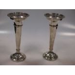 A pair of silver trumpet vases with cupped necks and pierced rims