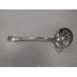 A George III silver sifting spoon, the handle decorated with bright cut engraving around a crest,