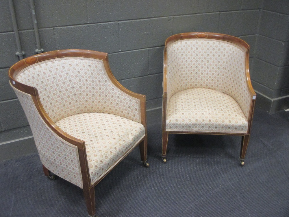 A pair of Edwardian finely upholstered "tub" chairs