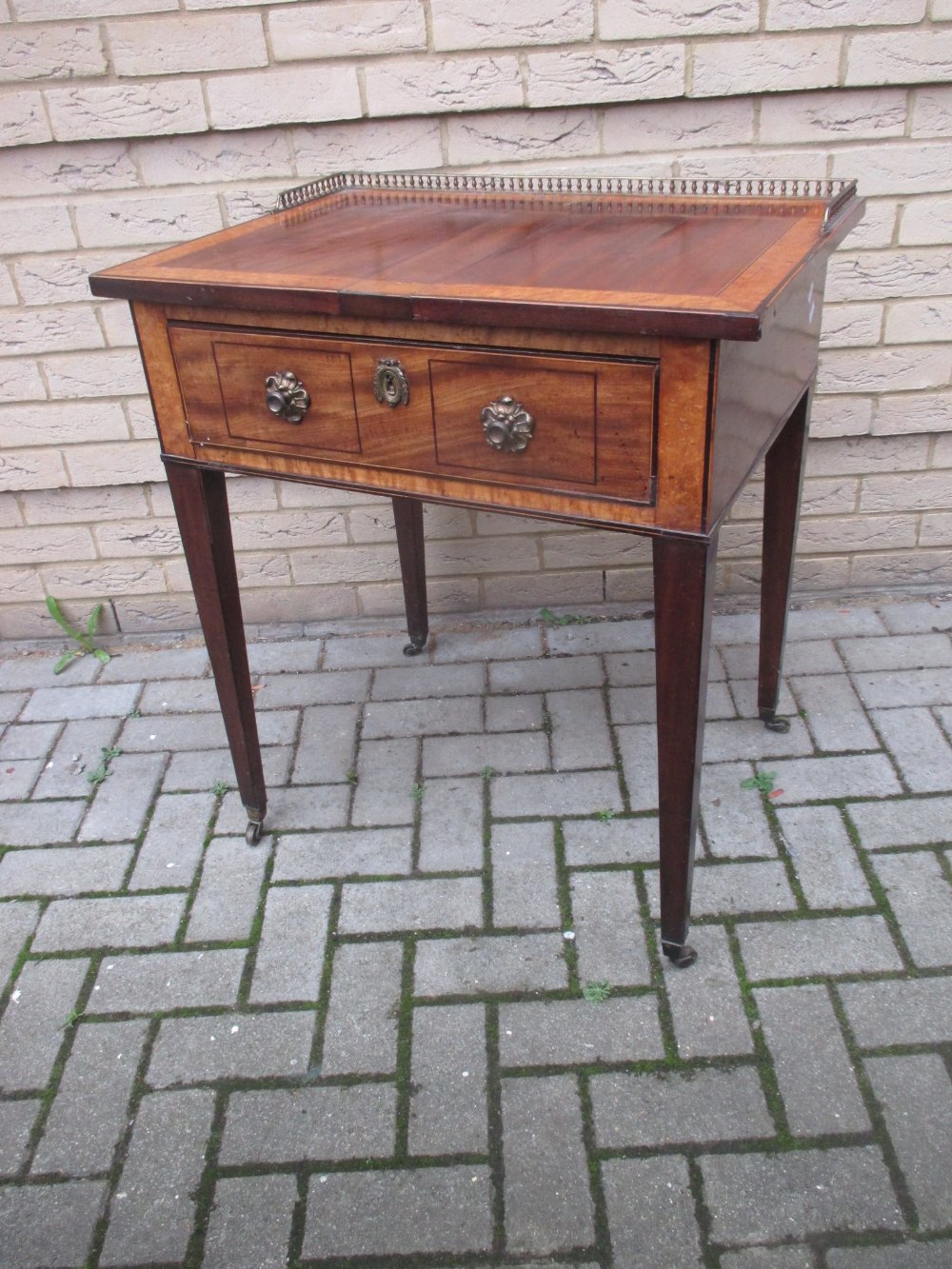 A 19th century mahogany and maplewood banded side table, with three quarter gallery and single