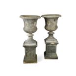 A pair of lead two handled garden urns,