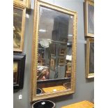 A large gilt framed mirror, with beaded and moulded frame, 120 x 63cm