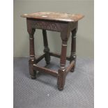 An antique oak joined stool with later top and carving