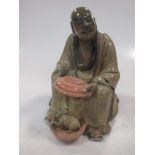 An early 20th century Chinese stoneware figure of a seated man