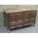 An 18th century oak mule chest with carved frieze and panelled front fitted two drawers under on