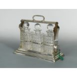 A silver plated and cut glass three bottle tantalus,