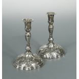 A pair of cast continental metalwares candlesticks,